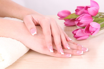 Obraz na płótnie Canvas Beautiful woman hands with french manicure and flowers