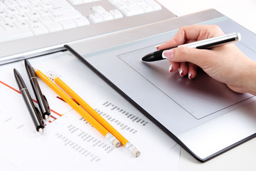 Female hand using graphics tablet on table close up
