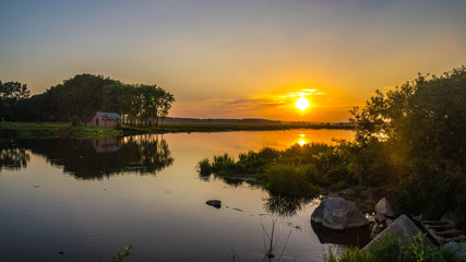 закат солнца у водоема с домиком