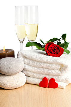 Romantic spa decoration with candles, spa stones and champagne