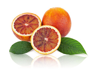 Ripe red blood oranges with cut and green leaves isolated on whi