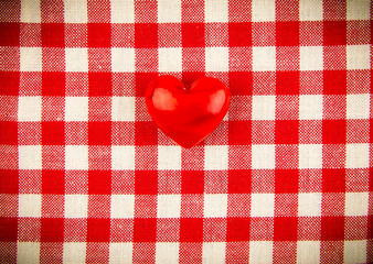 Textile texture in red and white cell with one red heart