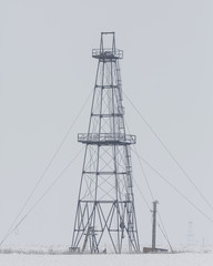 Abandoned oil and gas rig isolated on white and grey background