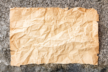 old crumpled paper on cement wall