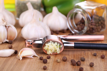 Composition with garlic press, fresh garlic and glass jars with