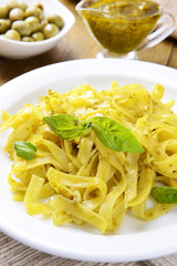 Delicious pasta with pesto on plate on table close-up