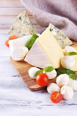 Different tasty cheese, on wooden table