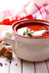 Tasty tomato soup on wooden table