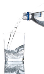 Pour water from bottle into  glass, on light blue background
