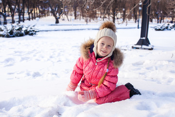 Fototapeta na wymiar Adorable little girl outdoor in the park on a winter day