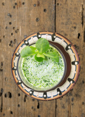 Obraz na płótnie Canvas Field green salad smoothie in galss and brown bowl