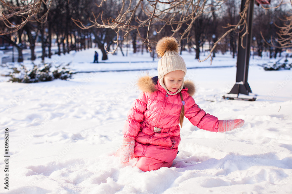 Wall mural Adorable little girl outdoor in the park on a winter day