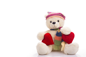 Teddy bear sitting with two valentine hearts