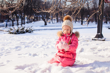 Adorable little girl outdoor in the park on a winter day