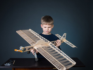Little boy holding the model airplane