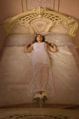 Young elegant girl lying on the bed