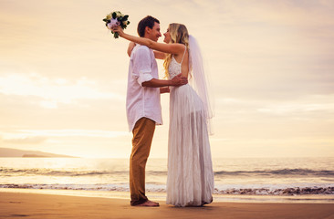 Fototapeta na wymiar bride and groom on beach at sunset