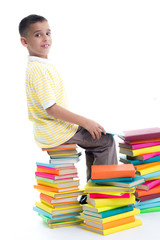 boy sitting on a pile of books and learn