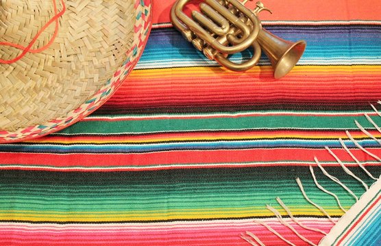 cinco de mayo Mexican fiesta poncho serape rug in bright colors with sombrero trumpet fiesta stock photo photograph image picture 