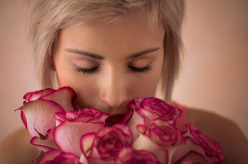 Young beautiful woman holding bouquet of pink roses