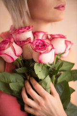 Unrecognizable woman holding bouquet of pink roses