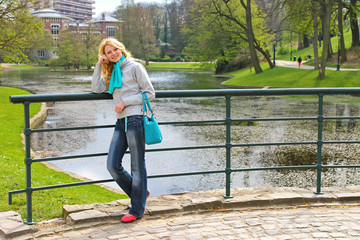 Young beautiful girl on a bridge in a park in Brussels