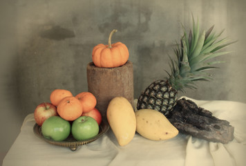 Still life apples, pineapple,pumpkin and mango in vintage style