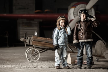 Fototapeta na wymiar Young aviators in homemade aircraft in a large hangar