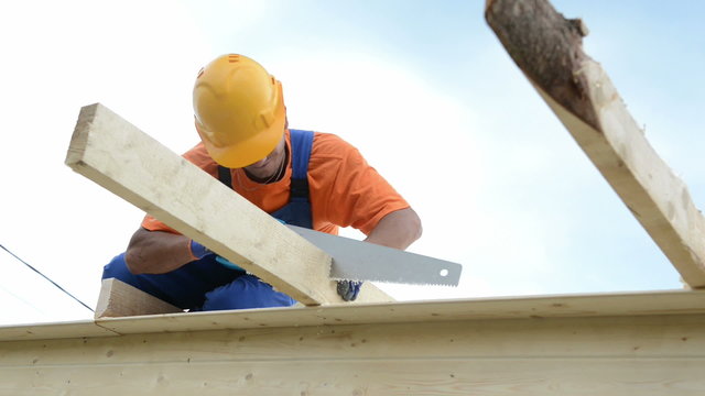 carpenter works with hand saw