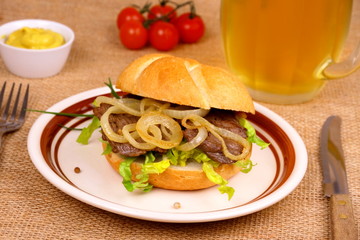 Grilled beef with onion rings in bun, mustard, beer