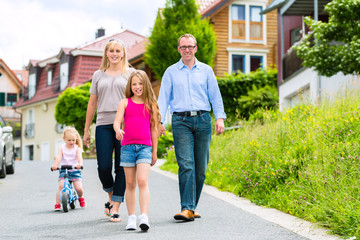 Familie macht Spaziergang durch Wohngebiet