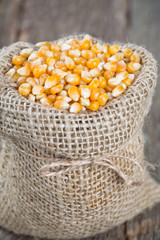 corn in burlap bag on wooden surface