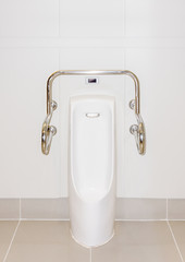 A male urinal with iron bar for accessibility in restroom