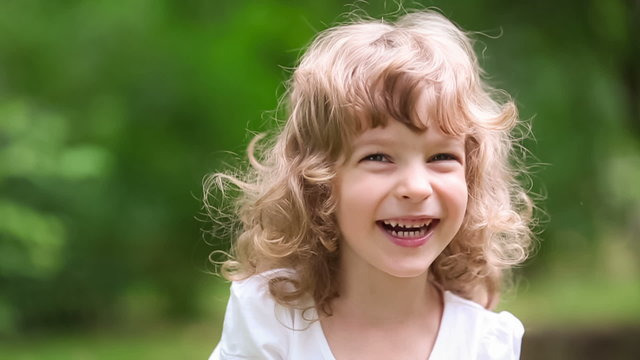 Happy child laughing outdoors in spring park
