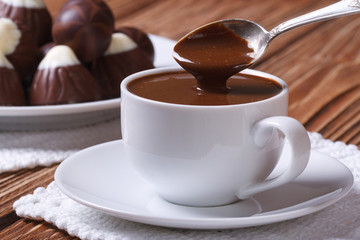 Spoon of chocolate being poured into a cup closeup