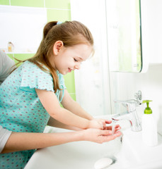 kid washing hands with mom