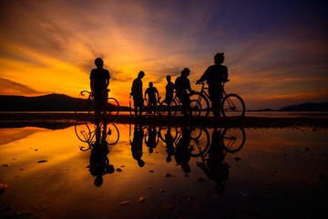Silhouette cyclists with reflection