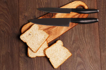 Three toasts of organic bread and two knives