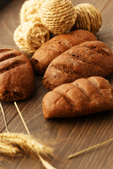 Bread loaves and rope balls on wood