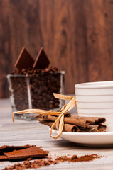 White cup with coffee, cinnamon and chocolate