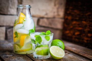 Water with lime,lemon and mint on rustic wooden table