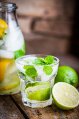 Water with lime,lemon and mint on rustic wooden table