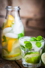 Water with lime,lemon and mint on rustic wooden table
