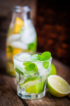 Water with lime,lemon and mint on rustic wooden table