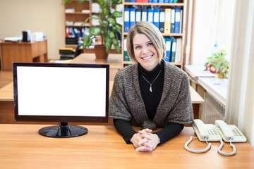 Representative woman sitting at desk with blank monitor