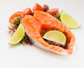 Raw salmon fillet with vegetables on white background