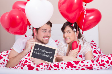 paar im bett mit herzballons