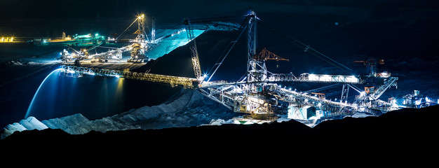 machine in an open coal mine at night - obrazy, fototapety, plakaty