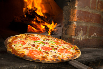 Pizza entering a wood oven