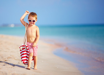 happy kid boy walking the summer beach